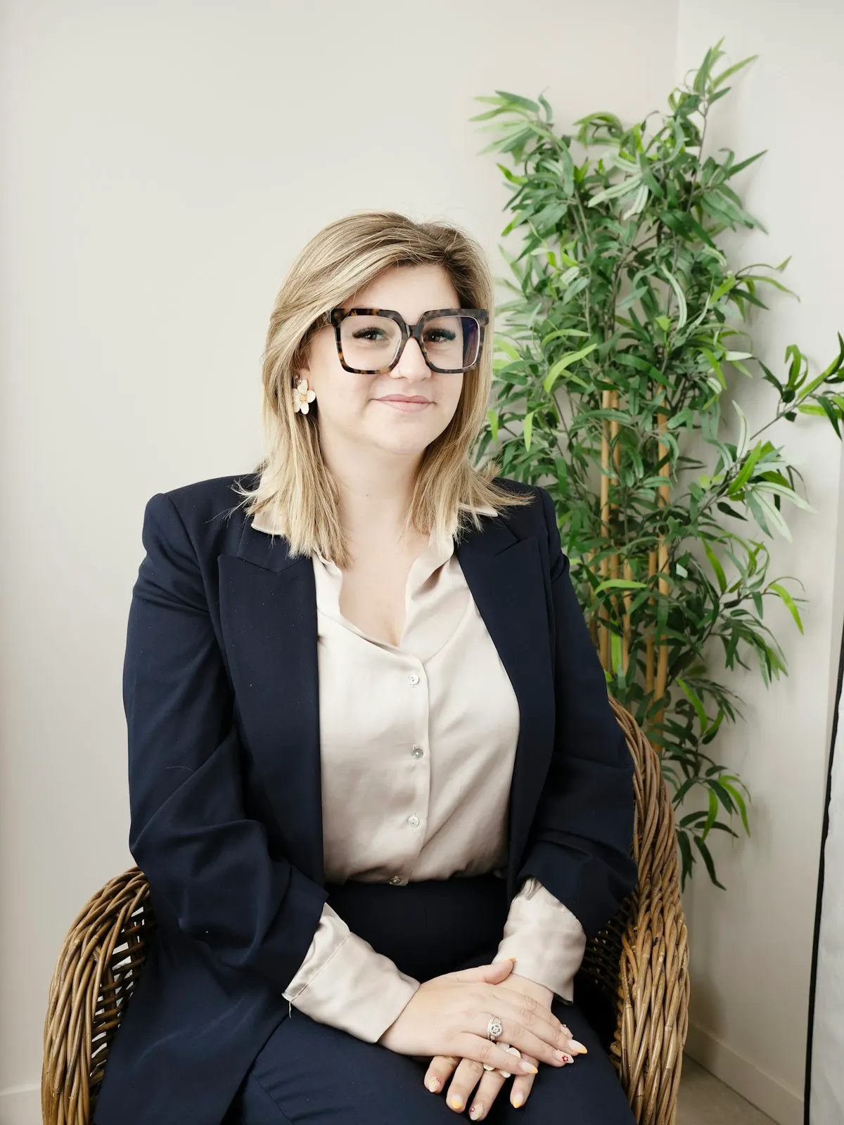 A consultant seated in a bright room beside a plant