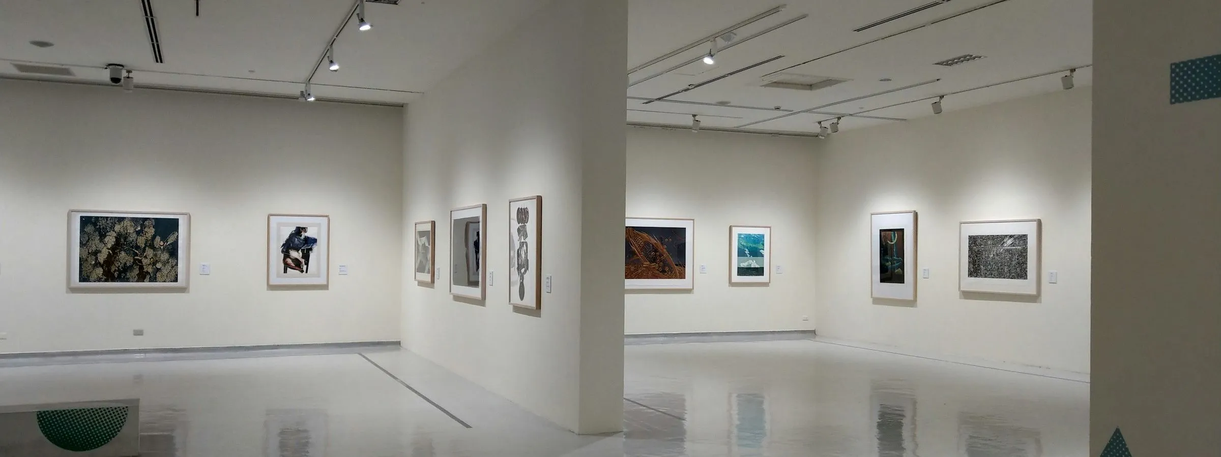 A bright studio shop with framed prints leaning along a long white wall