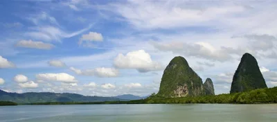 A green karst rising over a calm bay